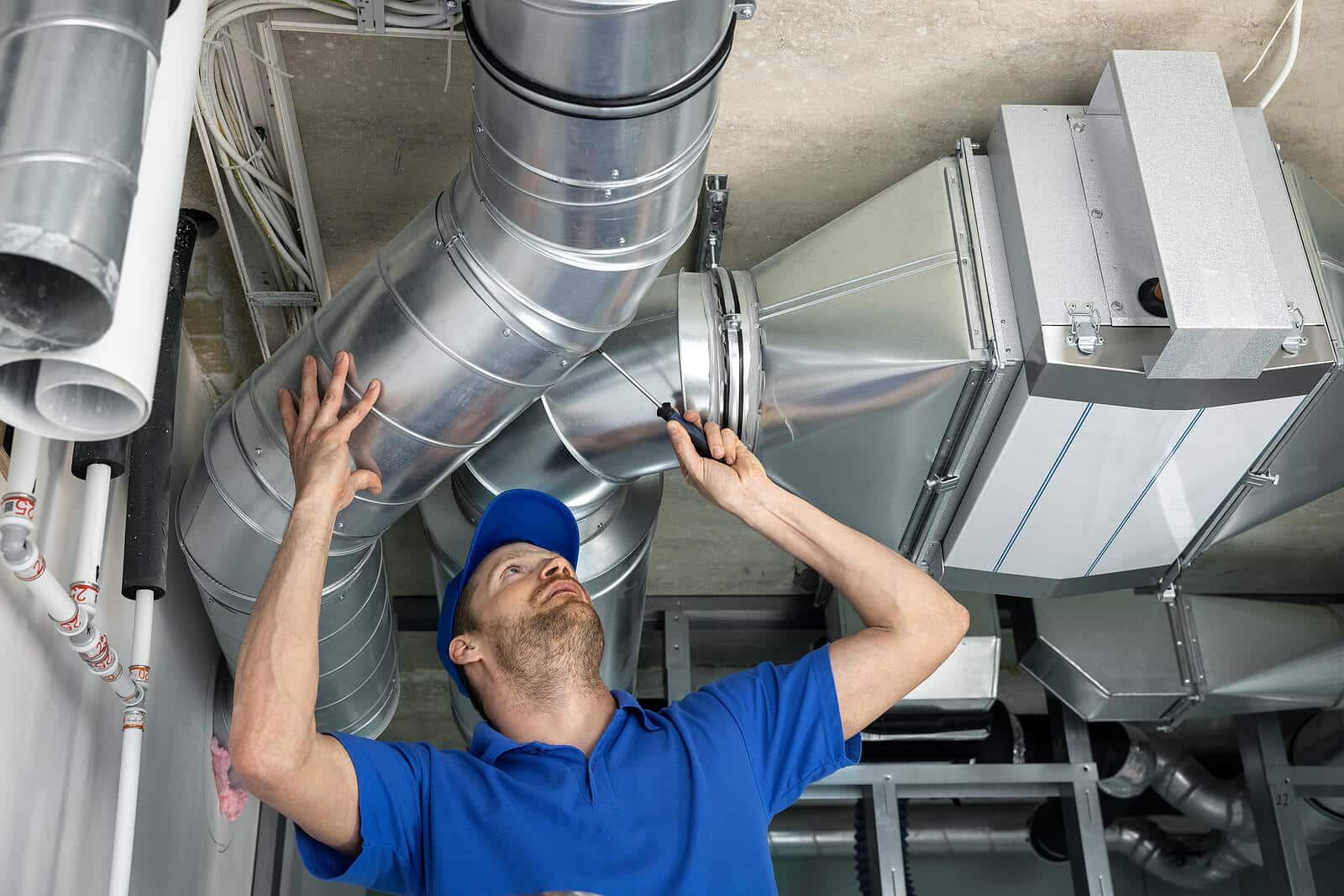 HVAC technician inspecting and repairing air ducts in Irvine