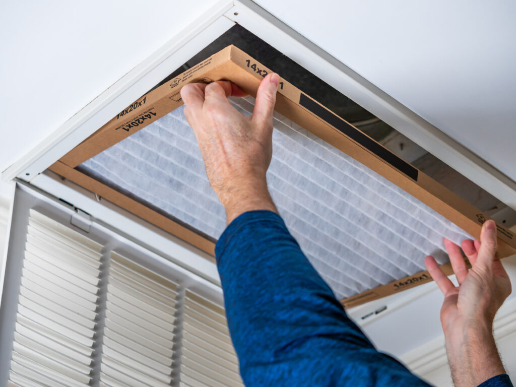 HVAC technician replacing a home air filter in Irvine