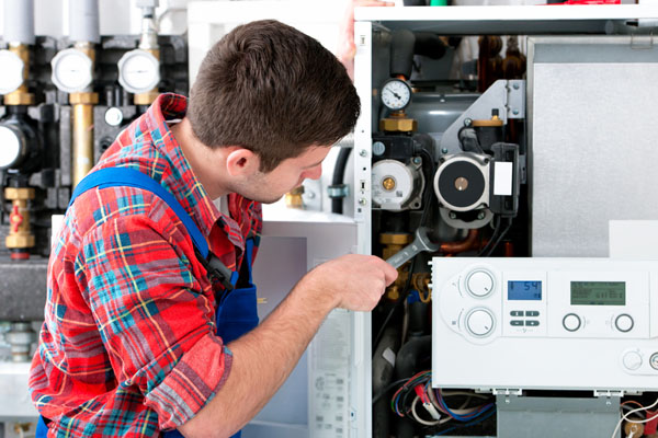 Heating technician repairing boiler controls in Irvine