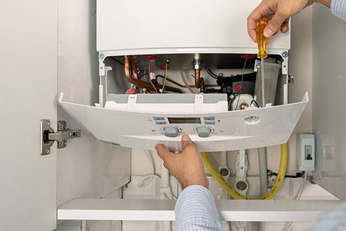 Heating technician repairing a residential boiler in Irvine