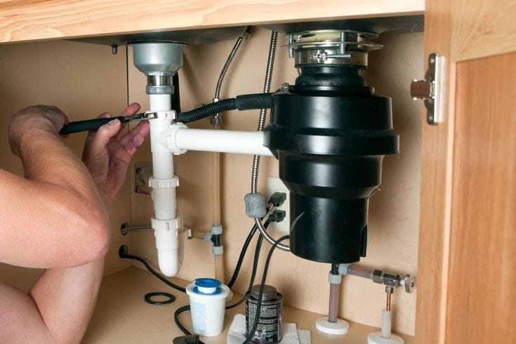 Plumber repairing a garbage disposal in Irvine