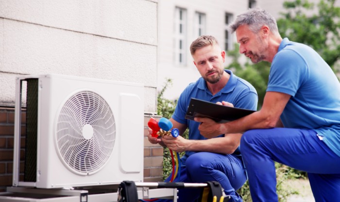 HVAC technicians installing an outdoor air conditioning unit in Irvine