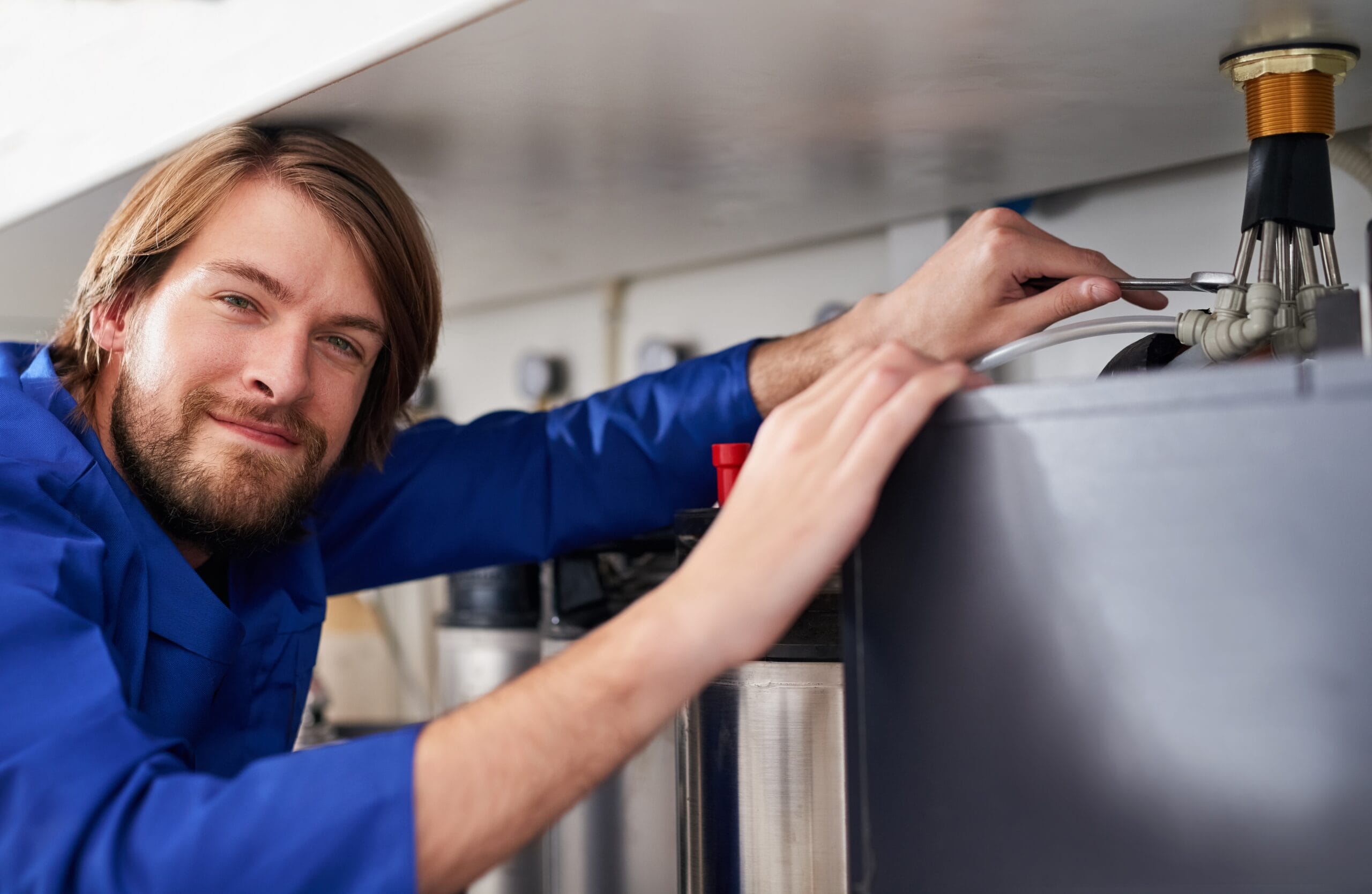 Technician servicing a residential water heater tank in Irvine